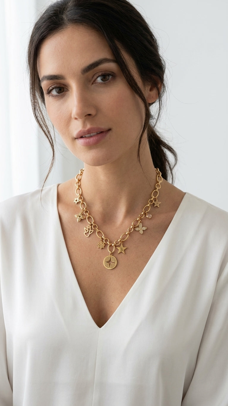 Model wearing Envy gold oval link chain multi-charm necklace with cream v-neck top