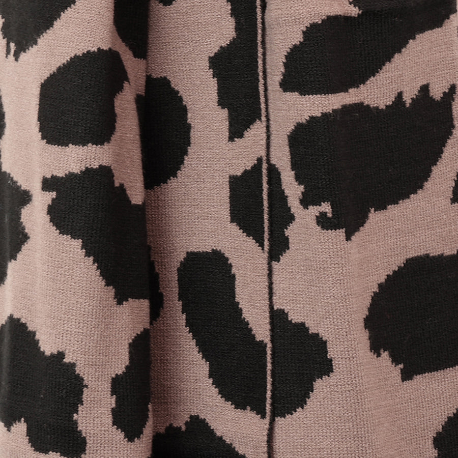 Close-up of the POM Carly scarf fabric, showing the soft knit texture and bold taupe and black animal print pattern in detail.