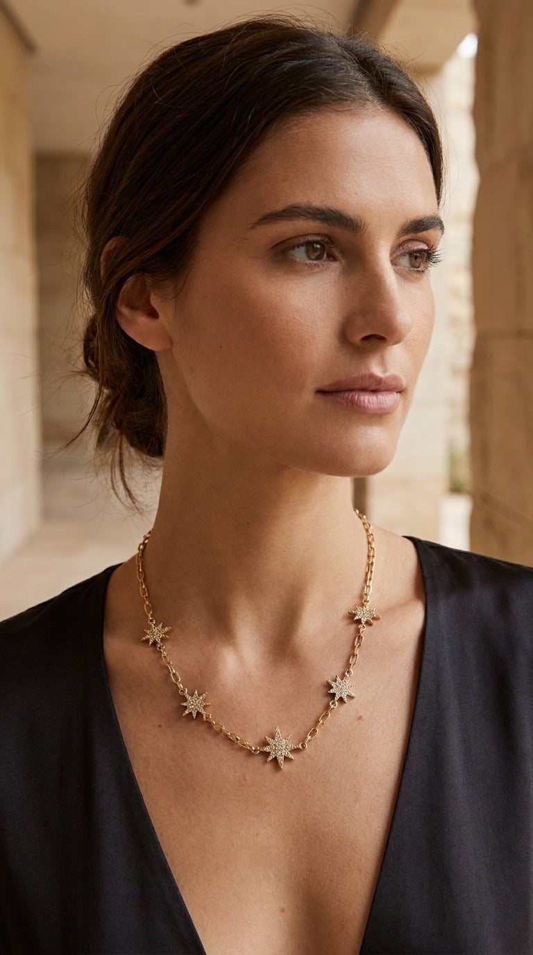 Model wearing Envy gold pavé star charm necklace with black v-neck dress