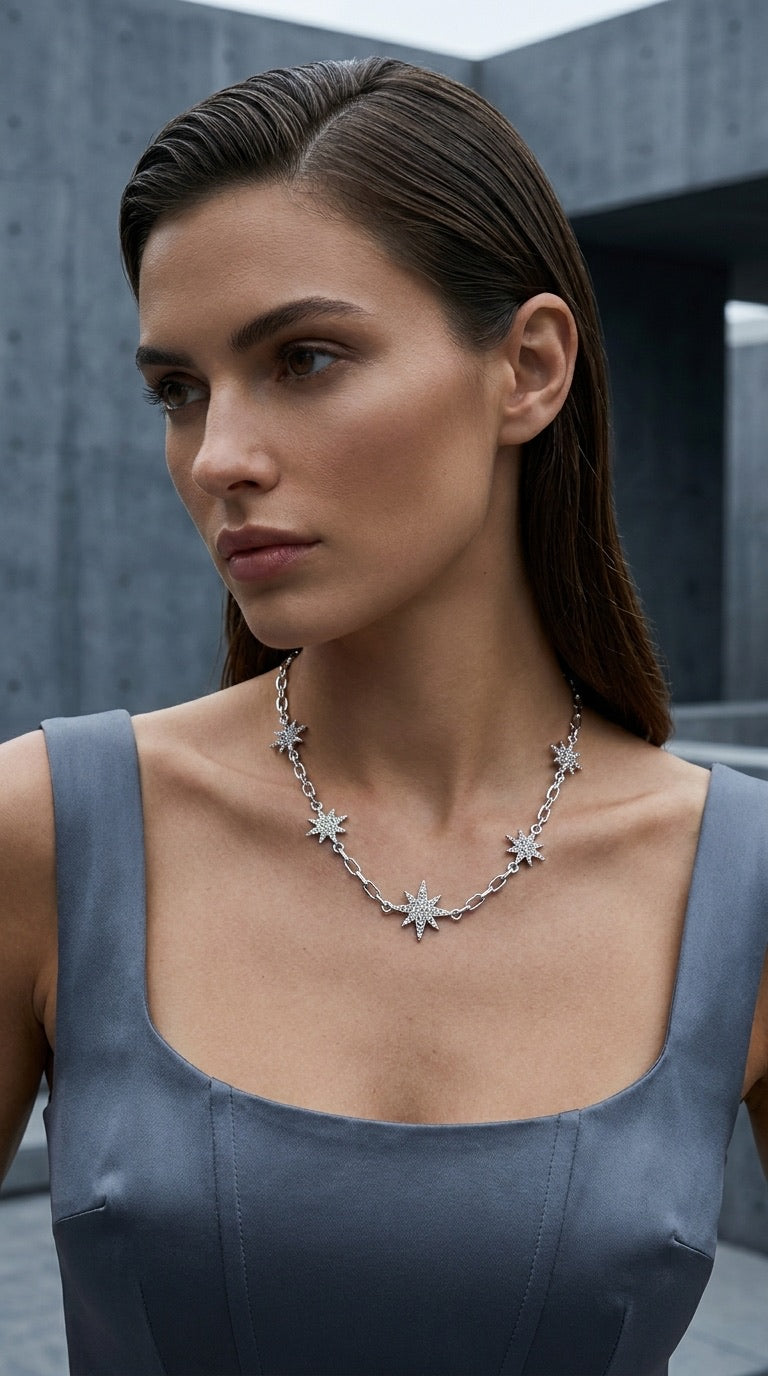 Model wearing Envy silver pavé star charm necklace with grey satin dress