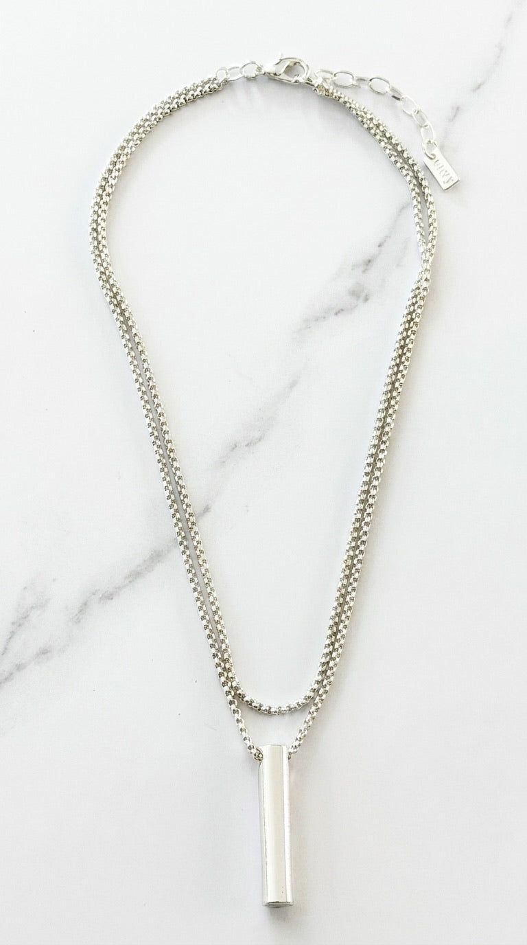 Envy silver double-layer box chain necklace with cylindrical bar pendant on marble background