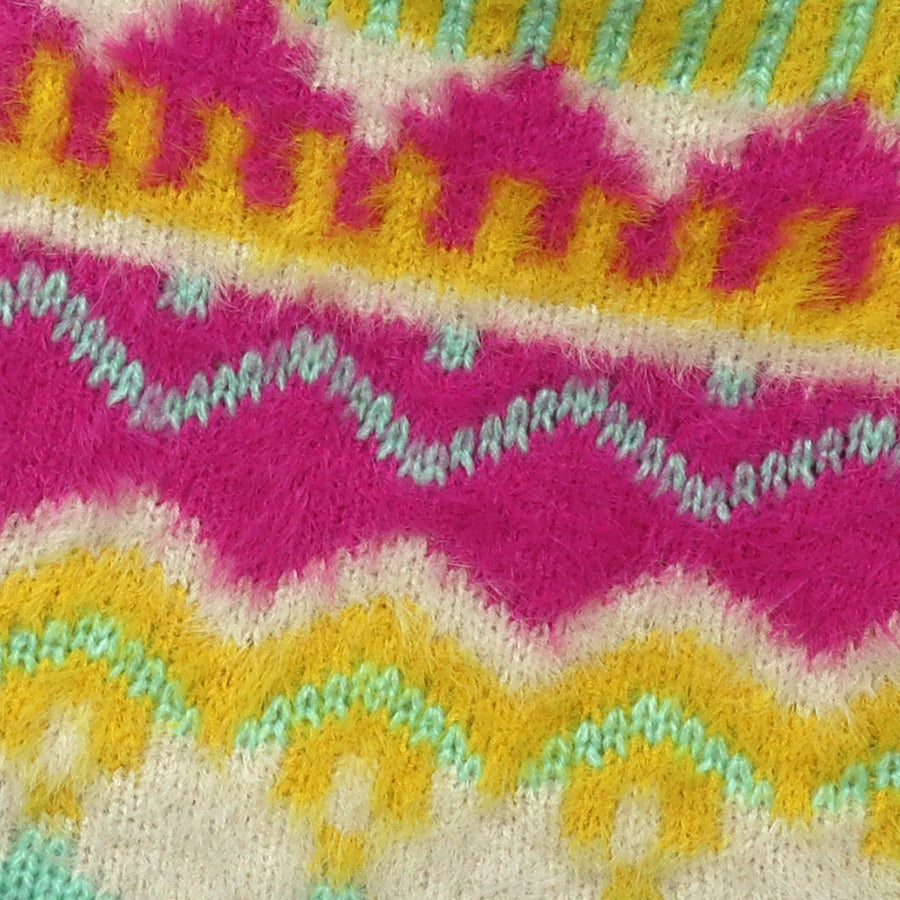 Close-up of the POM Mia neon hot water bottle fluffy knit cover, showing the bold wave pattern in hot pink, orange, yellow, mint and white with a soft, fluffy texture.