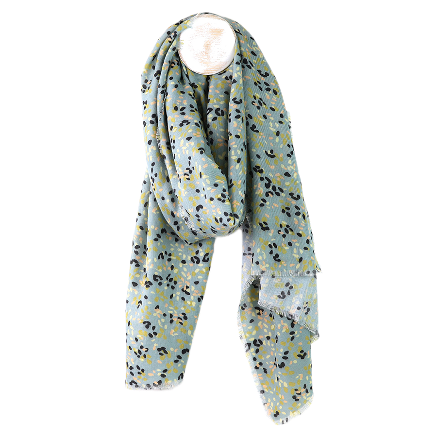 POM pale mint green ditsy print recycled polyester scarf draped on a mannequin stand against a white background, showing the scattered navy, yellow-green and blush leaf print all over with a delicate fringe edge.