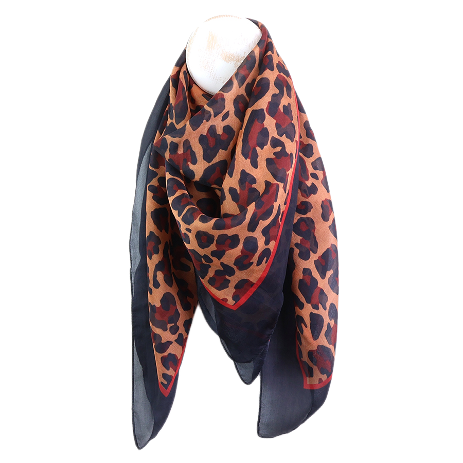 POM camel and navy leopard print silk scarf draped on a mannequin neck against a white background, showing the bold camel leopard print centre with navy border and red trim.