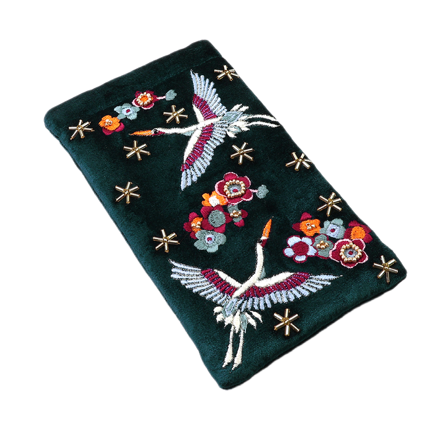POM Crane teal velvet glasses case laid flat, hand-embroidered with soaring cranes in white, pink and burgundy, vivid red, orange and sage blooms, and scattered gold star beads on deep teal velvet.
