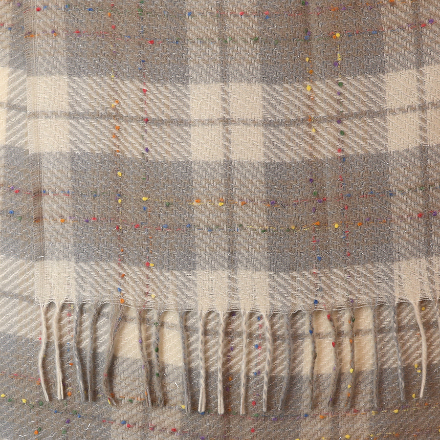 Close-up of the POM Olivia taupe mix tartan weave scarf fabric, showing the herringbone-style tartan weave in warm taupe and cream with scattered multicolour confetti fleck in red, yellow, blue and orange, with twisted fringe ends at the bottom.
