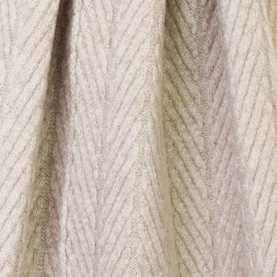 Close-up of beige knitted fabric with a textured pattern