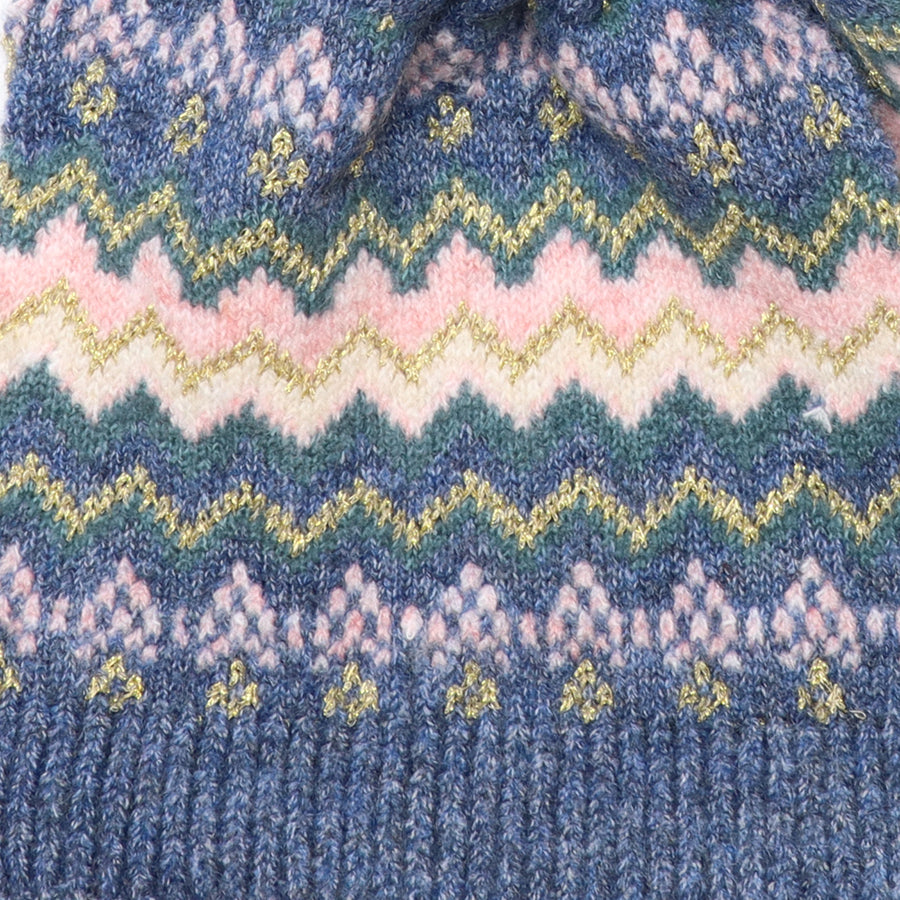 POM Sofia denim, pink and gold Fair Isle pull-through scarf looped through itself against a white background, showing the full Fair Isle chevron and diamond pattern in blush pink, teal and gold metallic thread on denim blue, with ribbed ends.