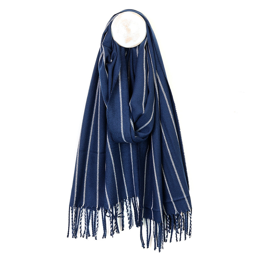 Close-up of the POM Henry navy pinstripe scarf fabric, showing the deep navy weave with fine cream pinstripe detail running diagonally across the soft textured cloth.