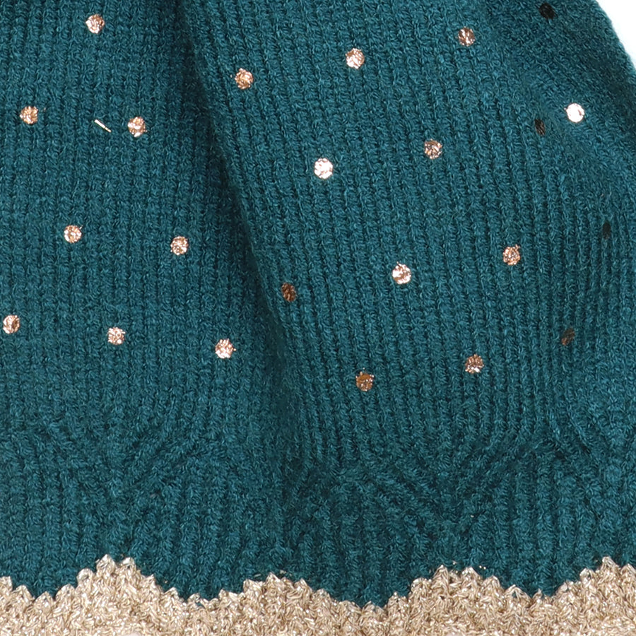 Close-up of the POM Yasmin teal knitted pull-through scarf fabric, showing the scattered rose gold and gold metallic sequin spots on the soft ribbed teal knit with scalloped gold lurex trim at the edge.