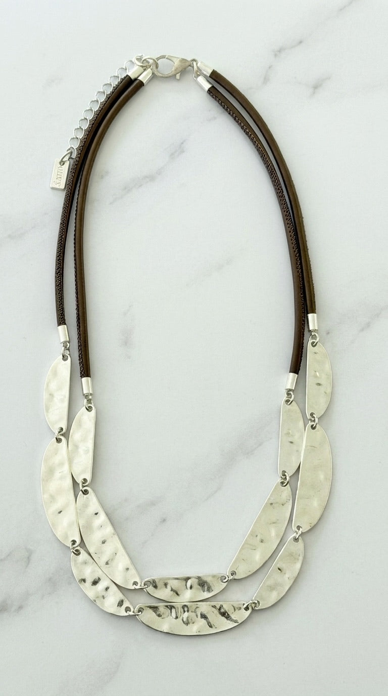 Envy double cord necklace with three rows of linked hammered silver oval plates on marble background