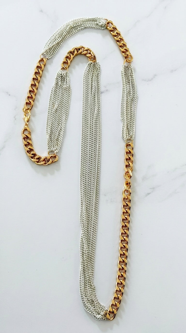 Envy long two-tone necklace with gold curb chain and fine silver multi-chain on marble background