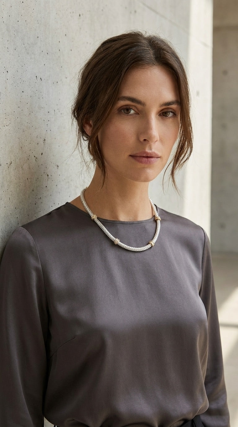 Model wearing Envy silver herringbone chain gold rondelle necklace with grey satin top