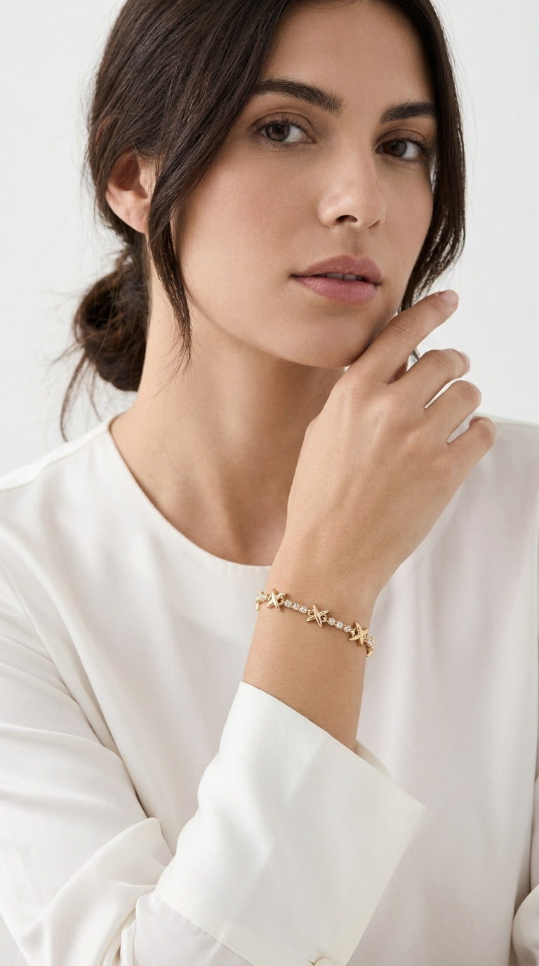  Model wearing Envy gold X-cross and crystal link slider bracelet with white long sleeve top
