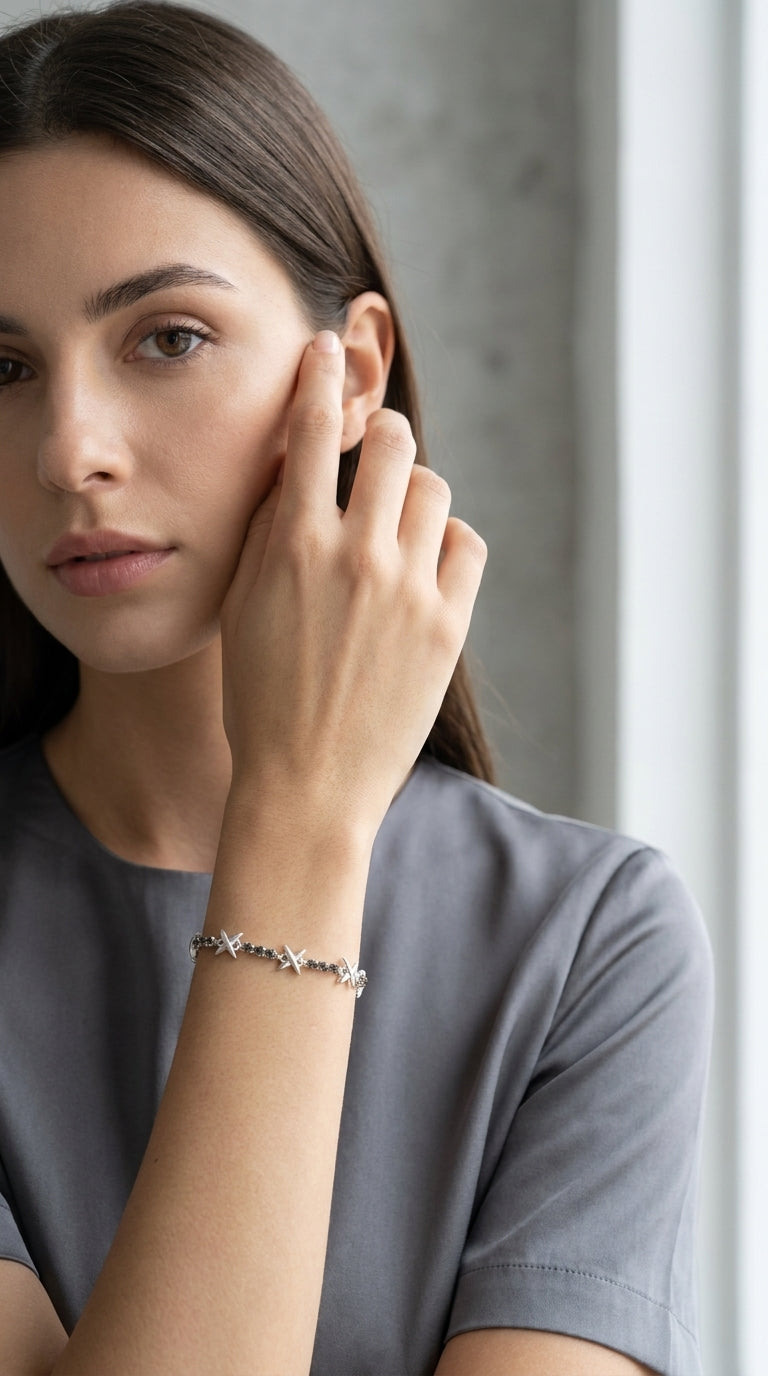 Model wearing Envy silver star and smoky crystal slider bracelet with grey t-shirt