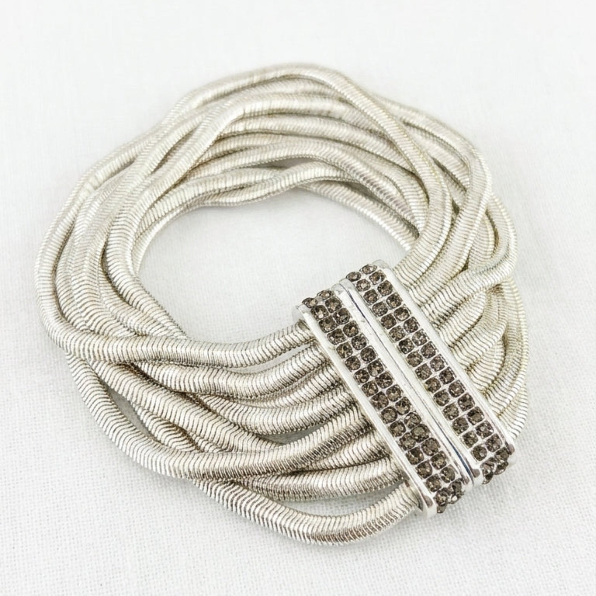 Envy silver multi-strand snake chain bracelet with smoky grey pavé crystal magnetic bar clasp on white background