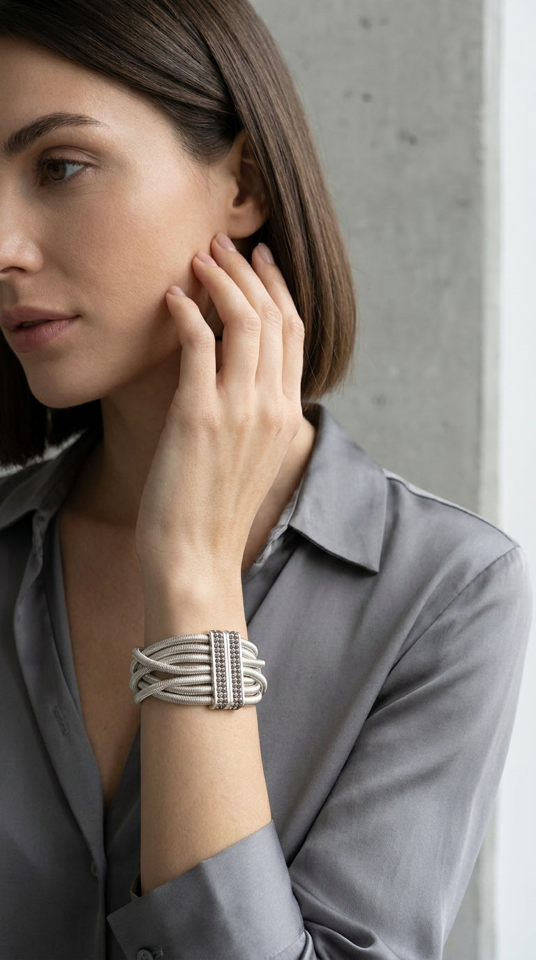 Model wearing Envy silver multi-strand snake chain bracelet with smoky pavé crystal magnetic clasp with grey satin shirt
