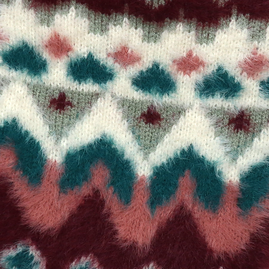 Close-up of the POM Imogen hot water bottle cover, showing the soft fluffy fair isle knit texture in teal, burgundy, blush pink and cream.