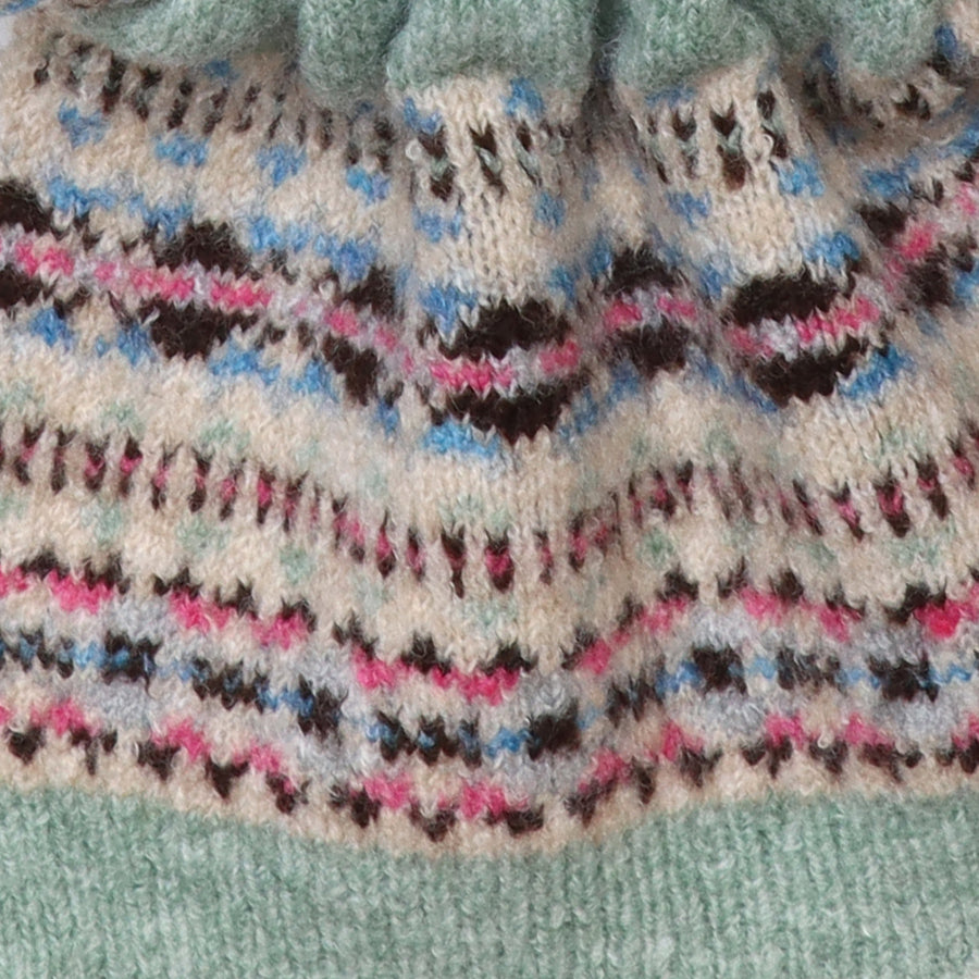 Close-up of the POM Iris scarf fabric, showing the detailed fair isle knit pattern in oatmeal, mint, pink, blue and brown with a mint ribbed border.