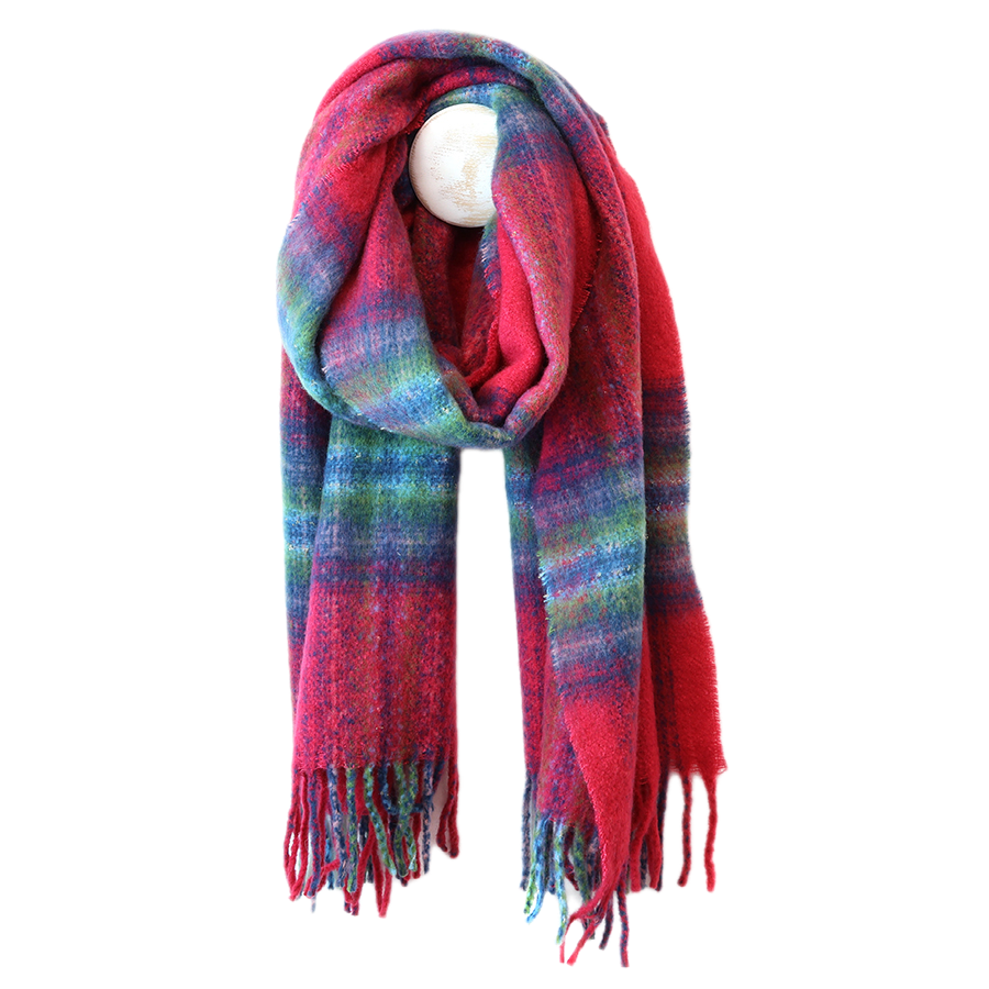 POM Miranda blue, green and raspberry mix scarf looped on a mannequin stand against a white background, showing the bold oversized check in raspberry red, teal blue, sage green and purple with a soft blended finish and multicolour twisted fringe ends.