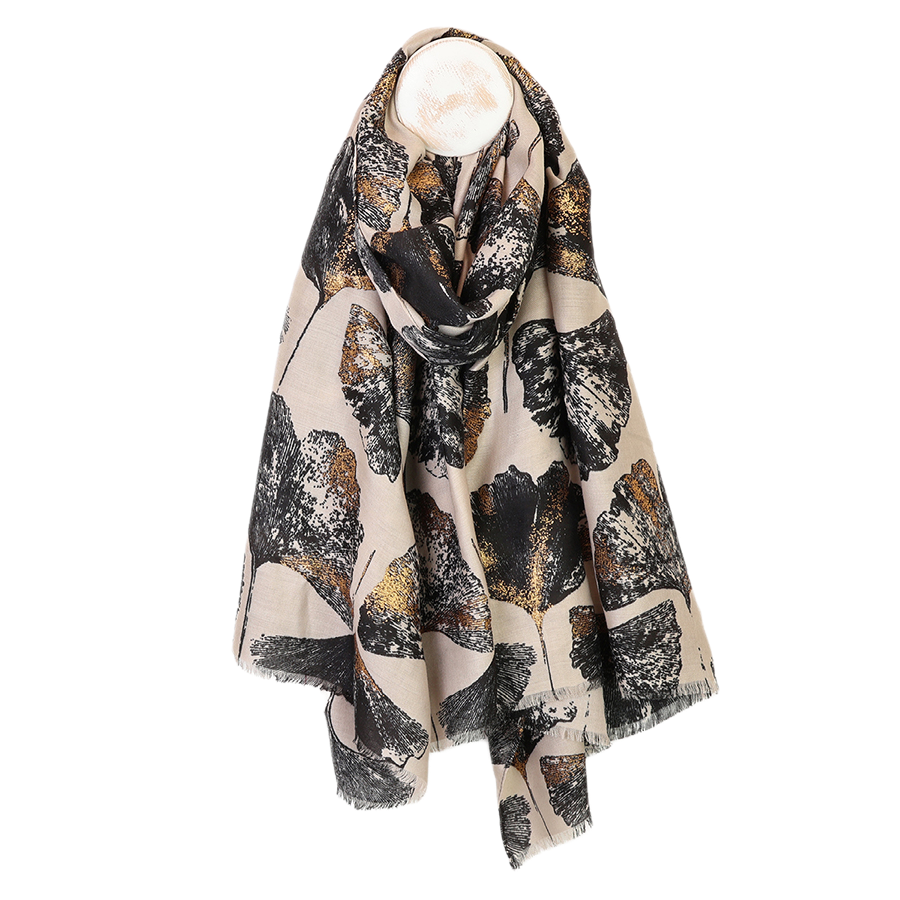 POM Greta natural mix ginkgo and metallic gold print scarf looped on a mannequin stand against a white background, showing the oversized black and metallic gold ginkgo leaf print on a warm natural ecru ground with delicate fringe edge.
