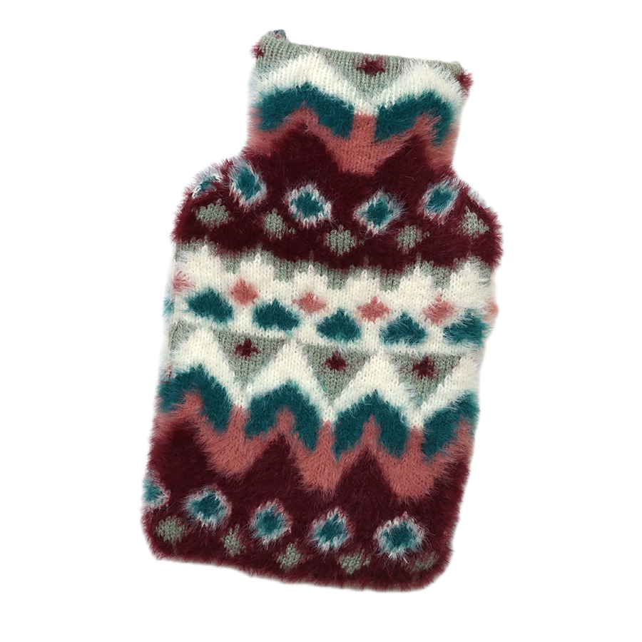 POM Imogen mini hot water bottle in a fluffy fair isle knit cover with burgundy, teal, blush pink and cream zigzag and diamond pattern, on a white background.