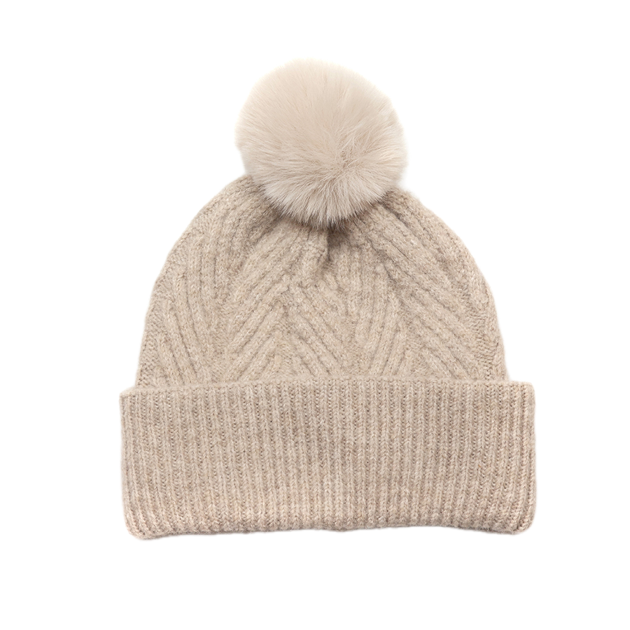 POM Charlotte oatmeal herringbone and cable knit bobble hat with fluffy cream faux fur pom pom and wide ribbed turn-up brim, shown against a white background.