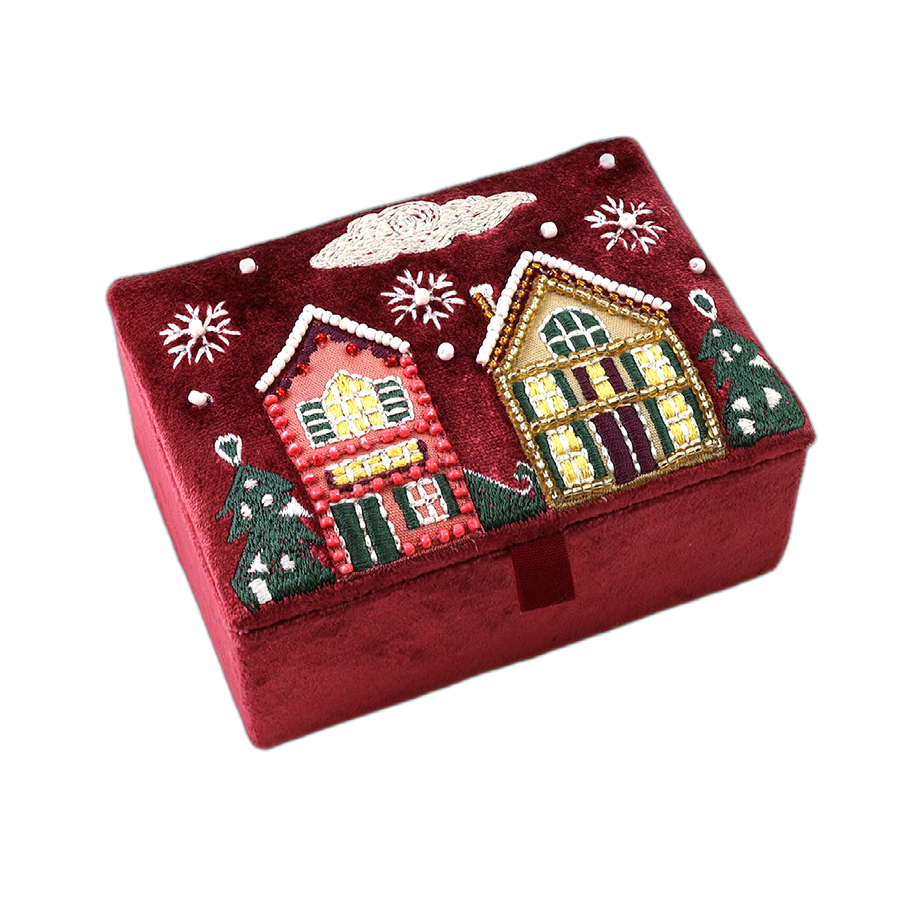 POM Winter Street wine velvet jewellery box shown closed, hand-embroidered on the lid with two glowing winter houses, snow-dusted Christmas trees, pearl snowflakes and chimney smoke detail on deep wine velvet.